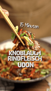 Knoblauch-Rindfleisch-Nudeln in einem Wok mit Frühlingszwiebeln und Sesam
